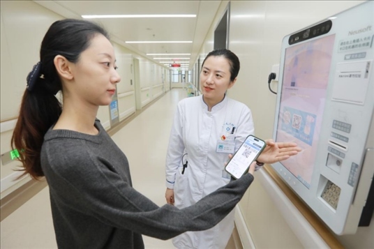 醫(yī)護(hù)人員引導(dǎo)患者在自助機(jī)前辦理自助入院手續(xù)。圖片來(lái)源：山東第一醫(yī)科大學(xué)第二附屬醫(yī)院