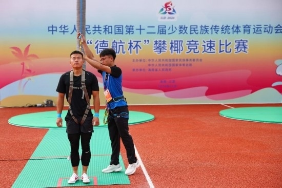 11月23日，工作人員為上海隊(duì)選手付樂樂（左）系安全繩。新華社記者 楊植森 攝