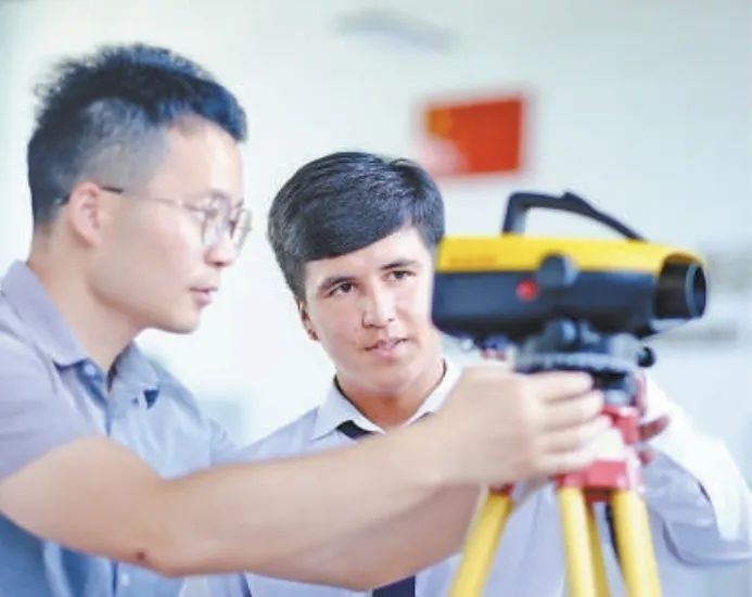 在塔吉克斯坦首都杜尚別的魯班工坊，來(lái)自天津城市建設(shè)管理職業(yè)技術(shù)學(xué)院的老師（左）為當(dāng)?shù)貙W(xué)生提供指導(dǎo)。新華社記者 鄭開君 攝