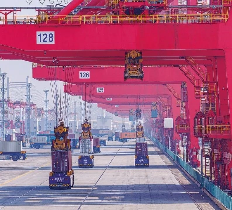 共建“一帶一路”國(guó)家在工作制度對(duì)接、技術(shù)標(biāo)準(zhǔn)協(xié)調(diào)、檢驗(yàn)結(jié)果互認(rèn)等方面強(qiáng)化合作、統(tǒng)一標(biāo)準(zhǔn)，貿(mào)易自由化便利化水平不斷提升。上海洋山港海關(guān)對(duì)接共建國(guó)家進(jìn)出口貨物相關(guān)標(biāo)準(zhǔn)，推動(dòng)通關(guān)一體化方式申報(bào)，提升通關(guān)效率。圖為無(wú)人駕駛的全自動(dòng)導(dǎo)引車在洋山港穿梭往來(lái)，搬運(yùn)集裝箱。王初 攝