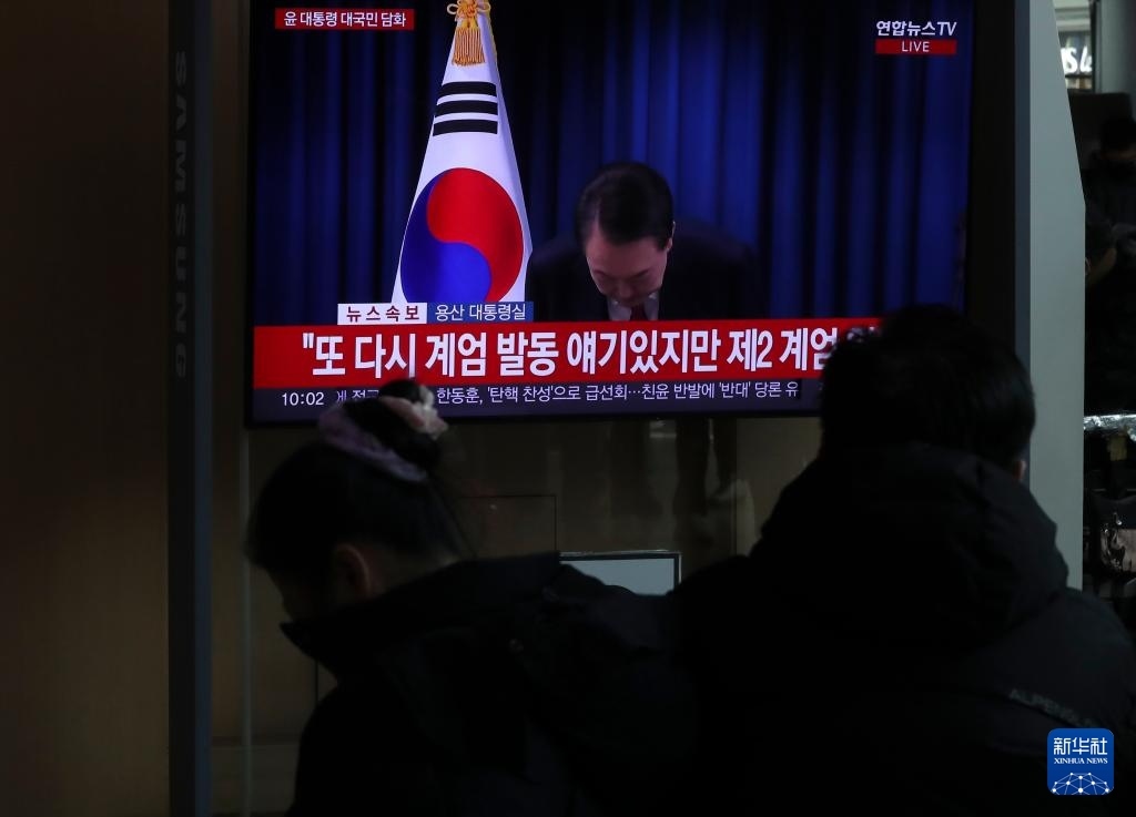 12月7日，在韓國(guó)首爾火車站，民眾觀看總統(tǒng)尹錫悅發(fā)表講話的電視畫面。新華社記者 姚琪琳 攝