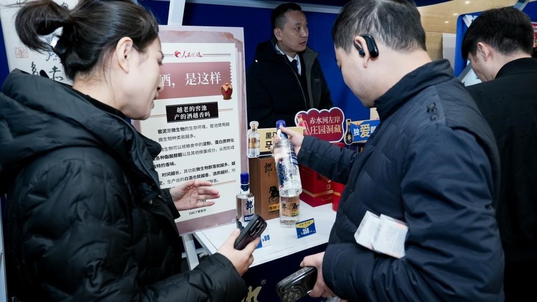 白酒展位負責人在為嘉賓介紹。張新攝