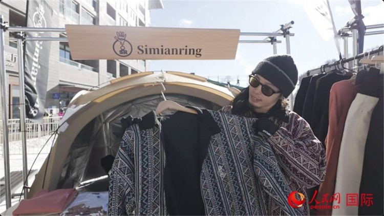 藤田周正在展示自己設(shè)計的滑雪服。人民網(wǎng)記者 袁蒙攝