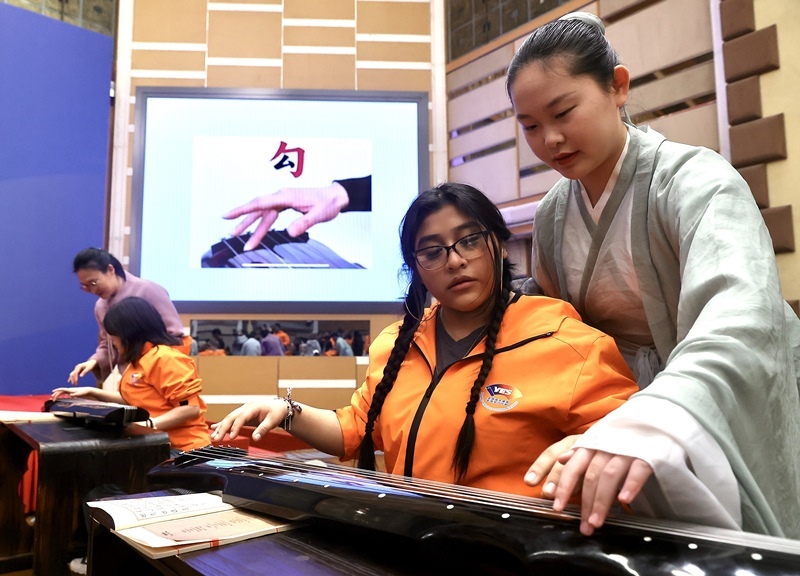 2024年3月20日，美國華盛頓州中學生代表團北京大學交流活動在北京大學英杰交流中心舉行。圖為來自華盛頓州的中學生體驗古琴。