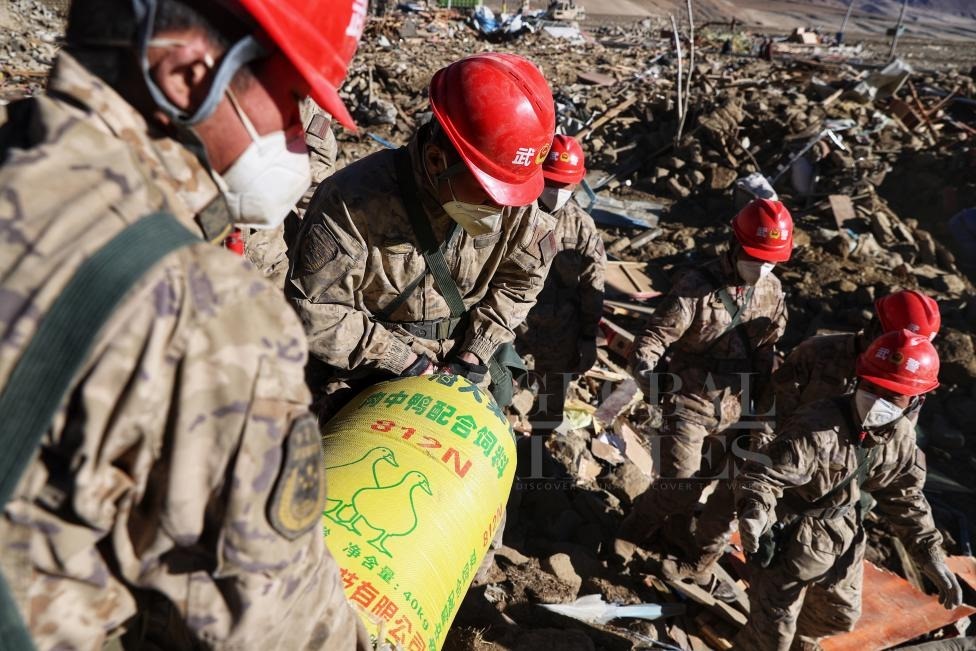 1月10日，定日縣長所鄉(xiāng)古榮村，武警官兵幫助受災群眾整理廢墟，搶救被掩埋的物資。環(huán)球時報記者崔萌攝