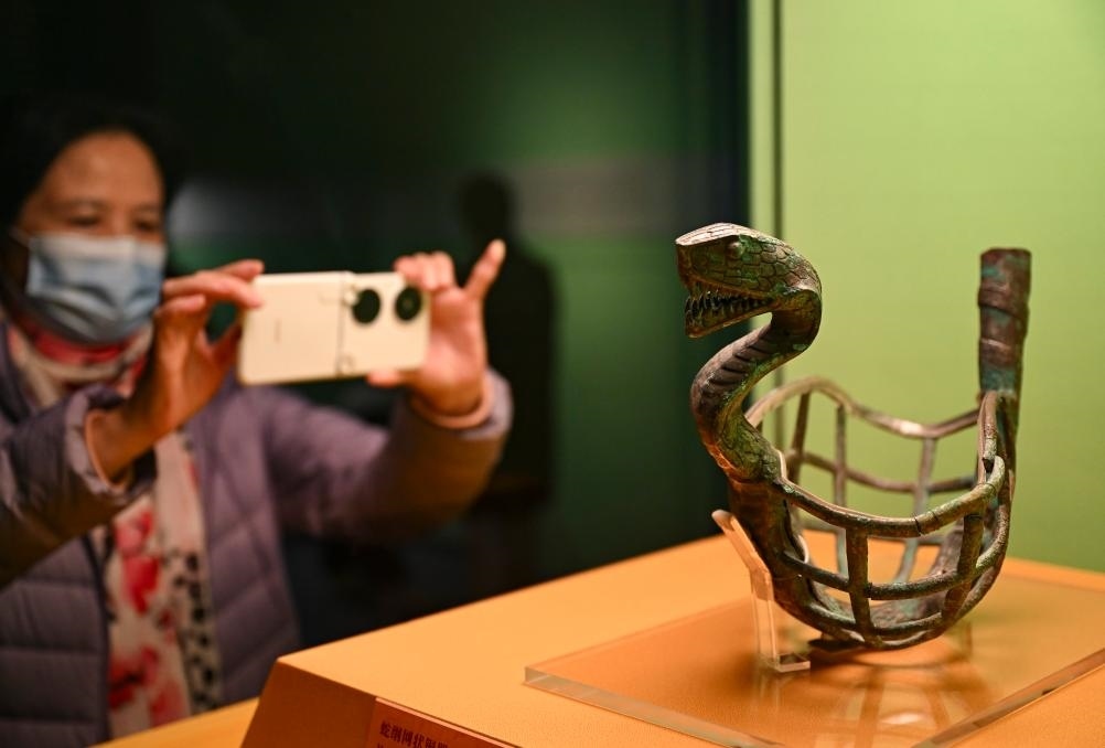 1月14日，觀眾在上海博物館蛇年迎春展拍攝展品蛇綱網(wǎng)狀銅器。新華社發(fā)（陳浩明攝）