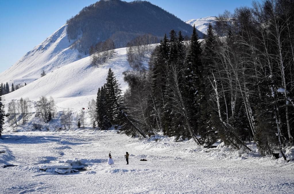2024年2月5日，兩名游客在新疆阿勒泰地區(qū)布爾津縣禾木村拍照。新華社記者 馬鍇 攝