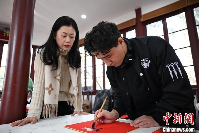 1月20日，外籍留學(xué)生在西泠印社社員李硯指導(dǎo)下寫福。當日，來自巴西、馬來西亞、加納、哈薩克斯坦的外籍留學(xué)生在浙江杭州西泠印社體驗福貼、春聯(lián)和篆刻，感受古老的中國傳統(tǒng)文化。中新社記者 王剛 攝