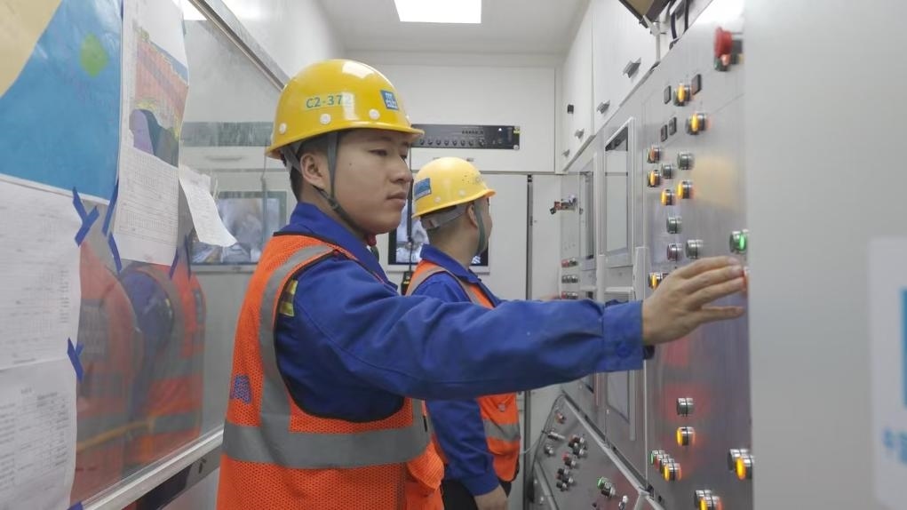 盾構(gòu)司機(jī)何曉波在駕駛室內(nèi)調(diào)試盾構(gòu)機(jī)參數(shù)。（劉芬攝）