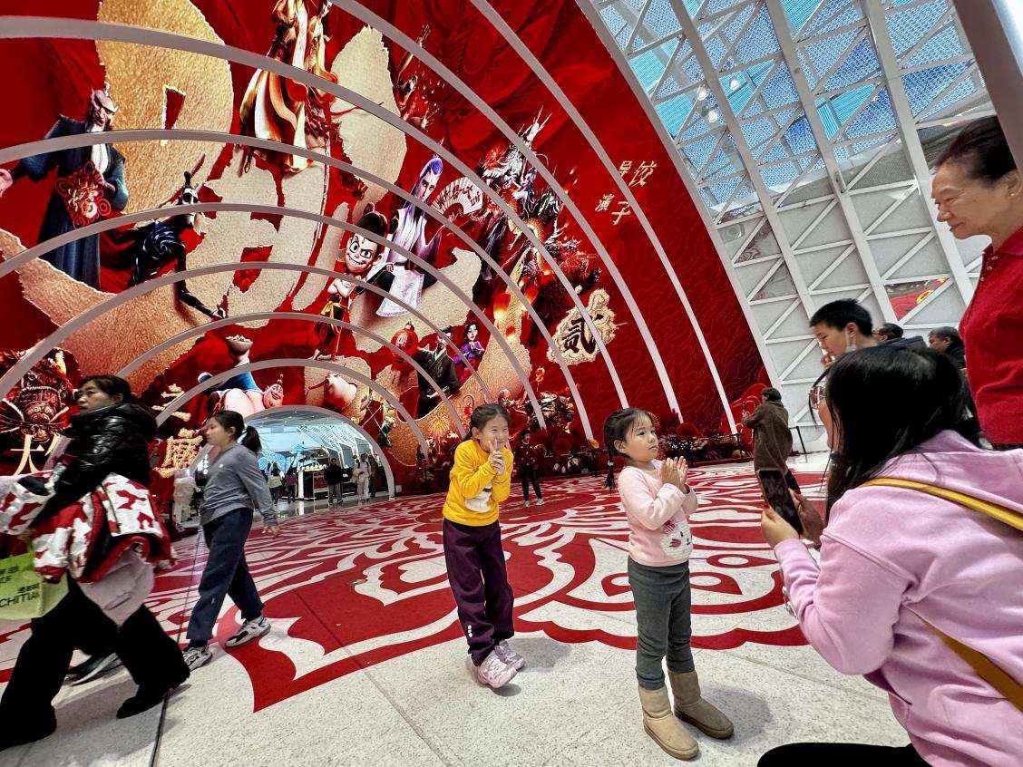 乙巳蛇年春節(jié)期間，影迷在《哪吒之魔童鬧海》巨幅海報前拍照打卡。