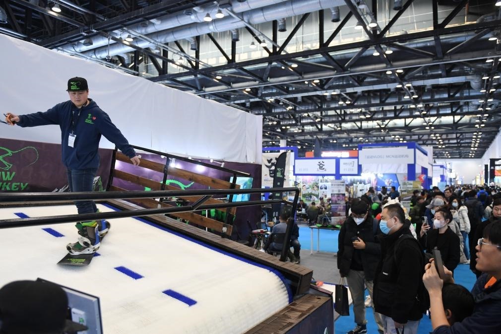 2023年2月11日，參觀者在展會上了解一款模擬滑雪設(shè)備。當(dāng)日，2023亞洲運動用品與時尚展在國家會議中心拉開帷幕。新華社記者 張晨霖 攝