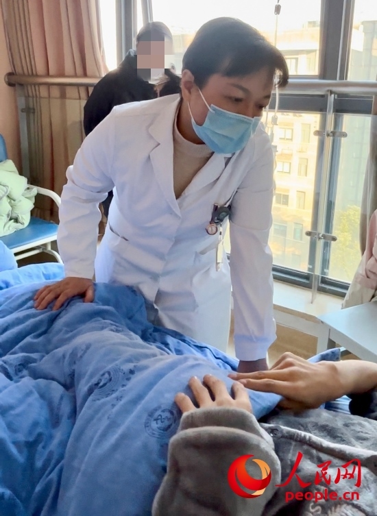 鄧茜查房時(shí)詢問(wèn)患者情況。人民網(wǎng)記者 金慧慧攝