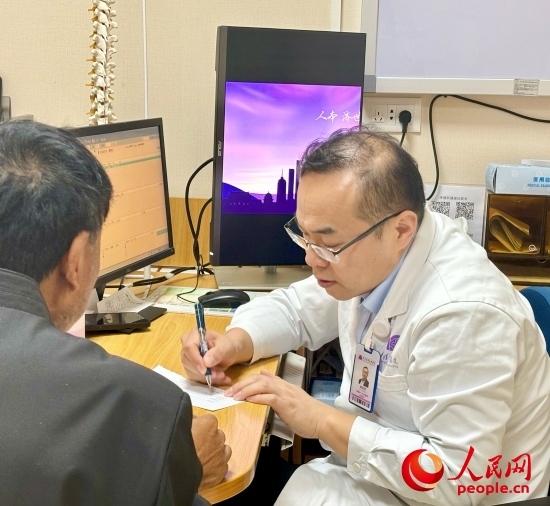 路桂軍接診時(shí)為患者寫(xiě)下用藥提示。人民網(wǎng)記者 金慧慧攝