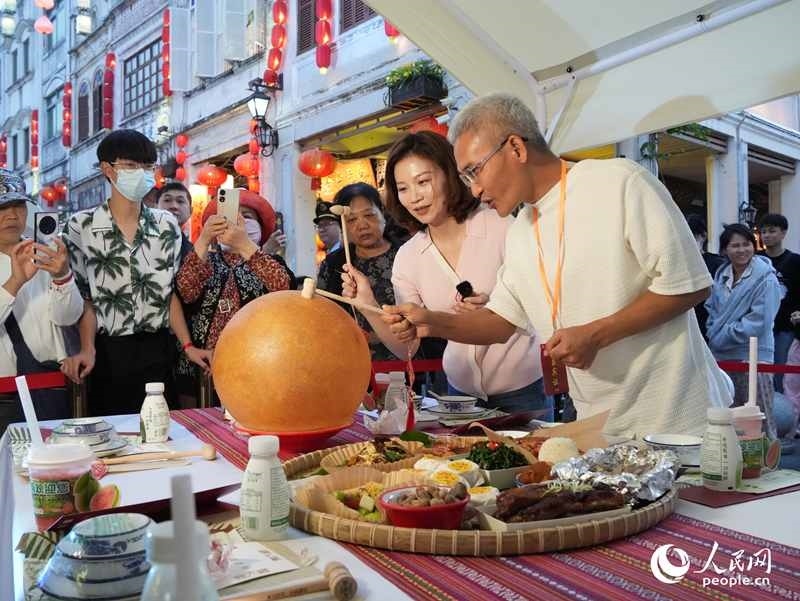 嘉賓品嘗海南傳統(tǒng)美食“煎堆”。人民網(wǎng)記者 張力洋攝