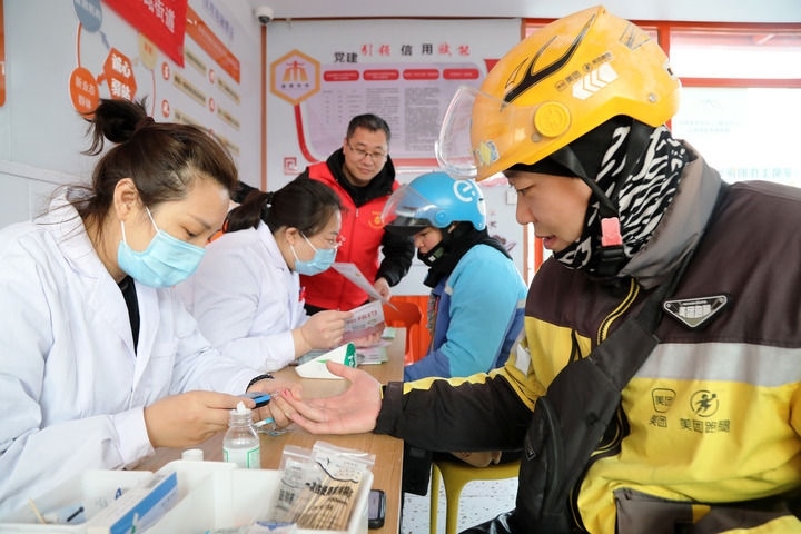 2025年3月5日，志愿者在山東省棗莊市市中區(qū)一工會驛站為外賣員免費測量血糖。新華社發(fā)（王海楠攝）