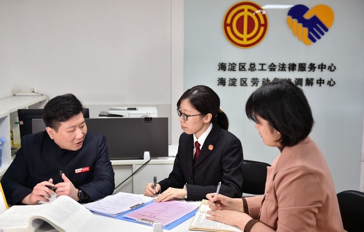2025年3月6日，在北京市海淀區(qū)總工會勞動爭議調(diào)解中心，海淀區(qū)人民法院法官王琰（中）與該中心工作人員就糾紛化解情況進行溝通。新華社記者 趙婷婷 攝