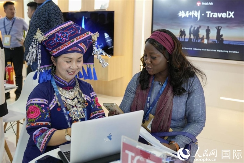 來(lái)自廣西的旅游業(yè)者同客戶交流。人民網(wǎng)塔里克·易卜拉欣攝