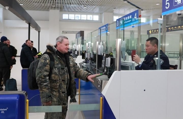 2024年12月10日，在黑河公路口岸旅檢大廳，黑河出入境邊防檢查站民警為首班次客車入境旅客辦理邊檢通關(guān)手續(xù)。當(dāng)日，中國黑河公路口岸—俄羅斯卡尼庫爾干公路口岸旅客運(yùn)輸正式開通。新華社發(fā)（劉松攝）