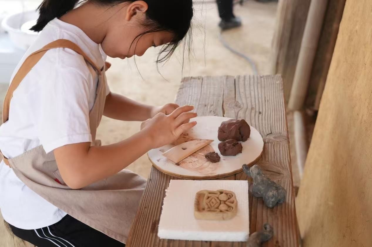 游客制作良渚特色陶藝品。良渚博物院供圖