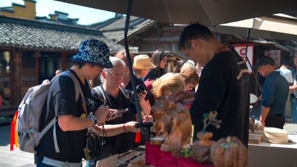 “五一”期間，游客正在烏鎮(zhèn)“水鄉(xiāng)碼頭”挑選購買文創(chuàng)產(chǎn)品。受訪者供圖