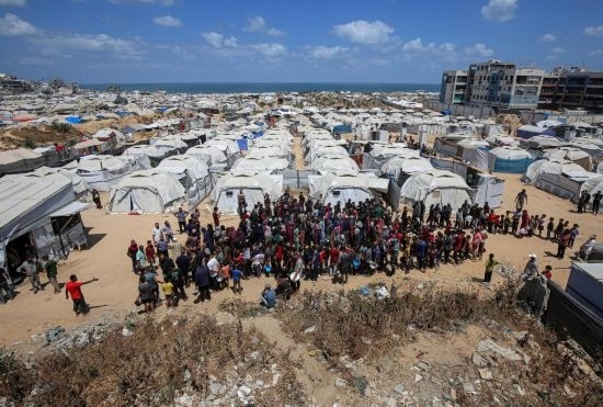 5月28日，人們在加沙城西部的沙提難民營等待領(lǐng)取救助食物。新華社發(fā)（里澤克·阿卜杜勒賈瓦德攝）