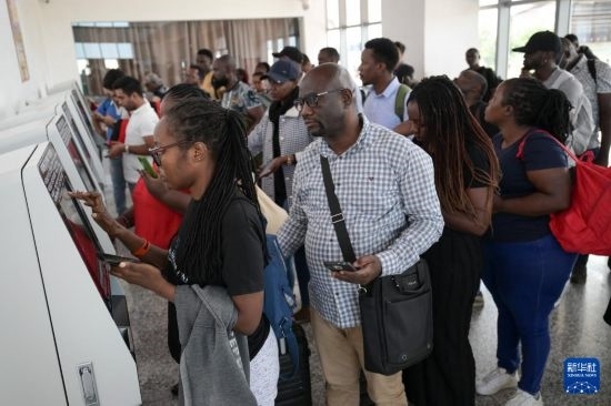 5月31日，在蒙內(nèi)鐵路內(nèi)羅畢站，乘客在自助取票機(jī)前排隊(duì)取票。新華社記者 楊光 攝