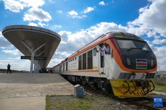 5月31日，在蒙內(nèi)鐵路內(nèi)羅畢站，機(jī)車(chē)駕駛員蔣立平（右）和博爾在即將開(kāi)往蒙巴薩的E2次列車(chē)上揮手致意。新華社記者 楊光 攝