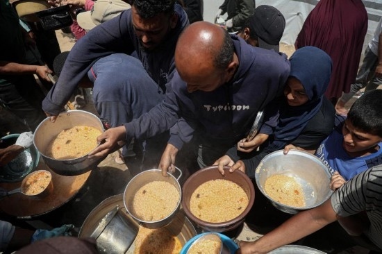 5月28日，人們在加沙城西部的沙提難民營領(lǐng)取救助食物。新華社發(fā)（里澤克·阿卜杜勒賈瓦德攝）
