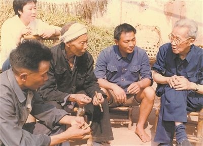 侯光炯(右一)和農(nóng)民在一起親切交流。 西南大學(xué)檔案館供圖